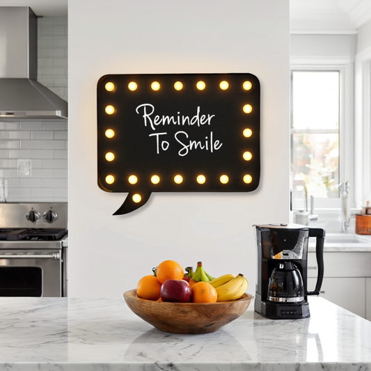 Decorative wall sign with 'Reminder To Smile' in a kitchen setting.