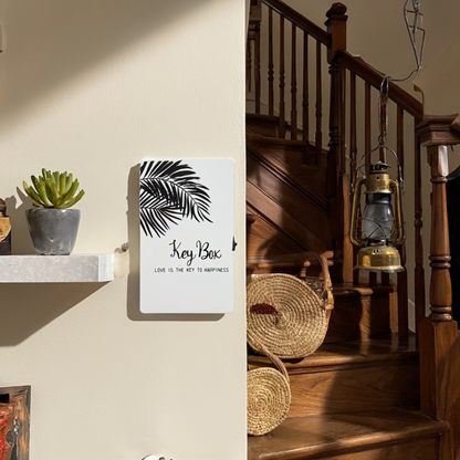 Key box with leaf design on a wall next to a wooden staircase with lanterns.